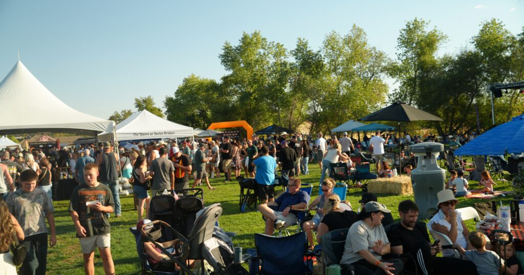 Crowded 12 Bridges Rib Cook-Off with sponsor booths and banners showcasing 12 Bridges Rib Cook-Off sponsorship support.