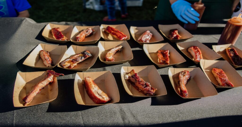 Ribs being prepared to pass out for people to enjoy at the 2025 12 Bridges Rib Cook-Off.